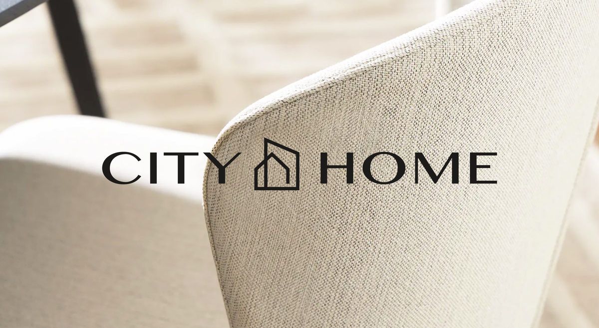 CITY HOME wordmark over a close-up of upholstered fabric