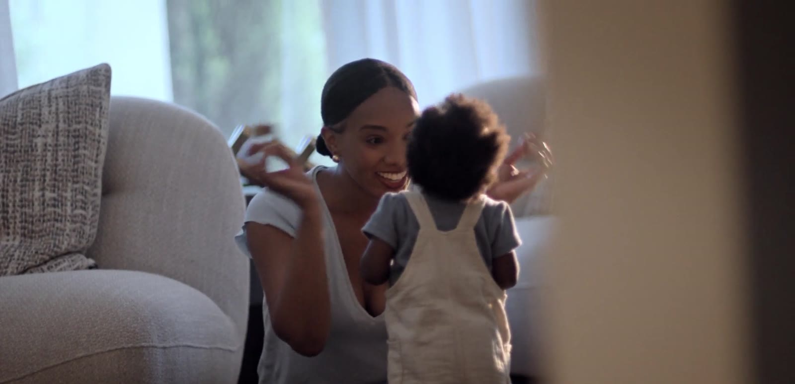 Mother cheering on her baby standing up