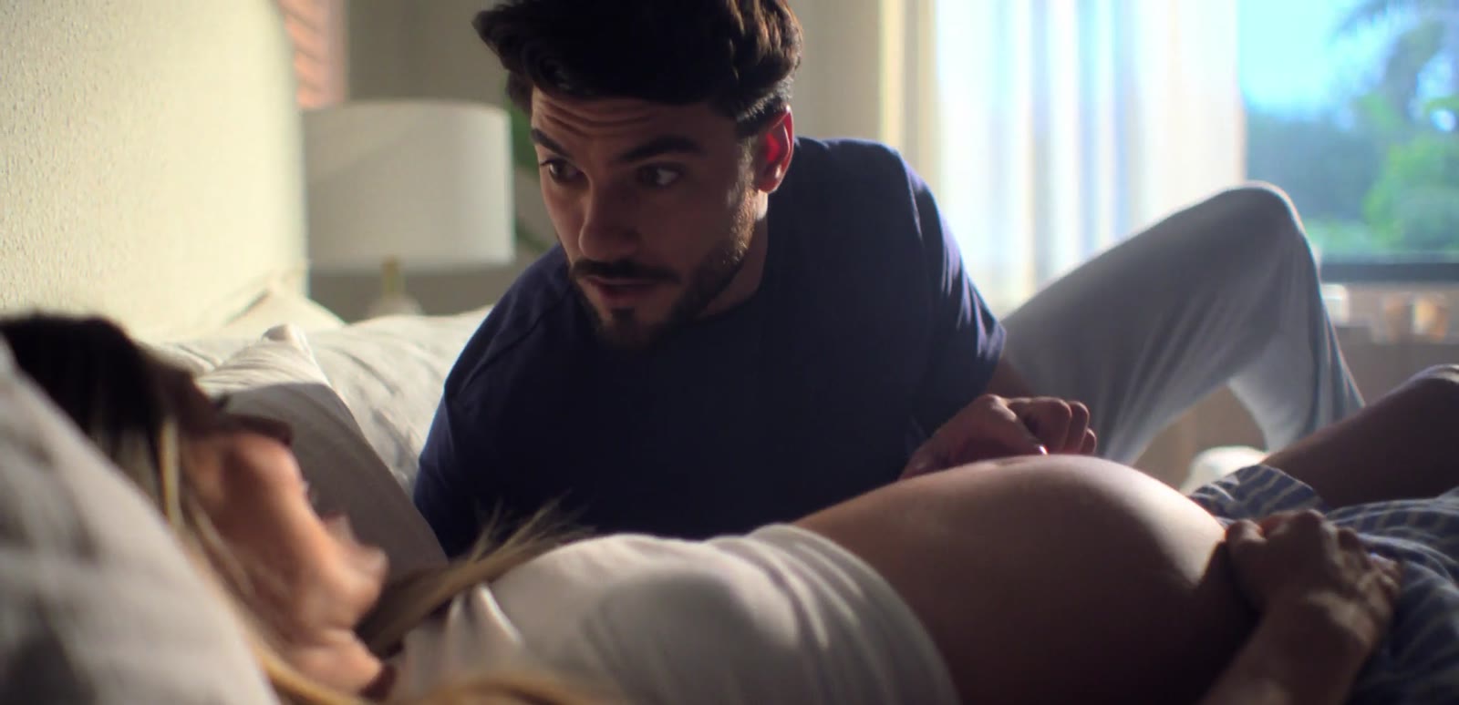 Husband feeling his pregnant wife’s belly