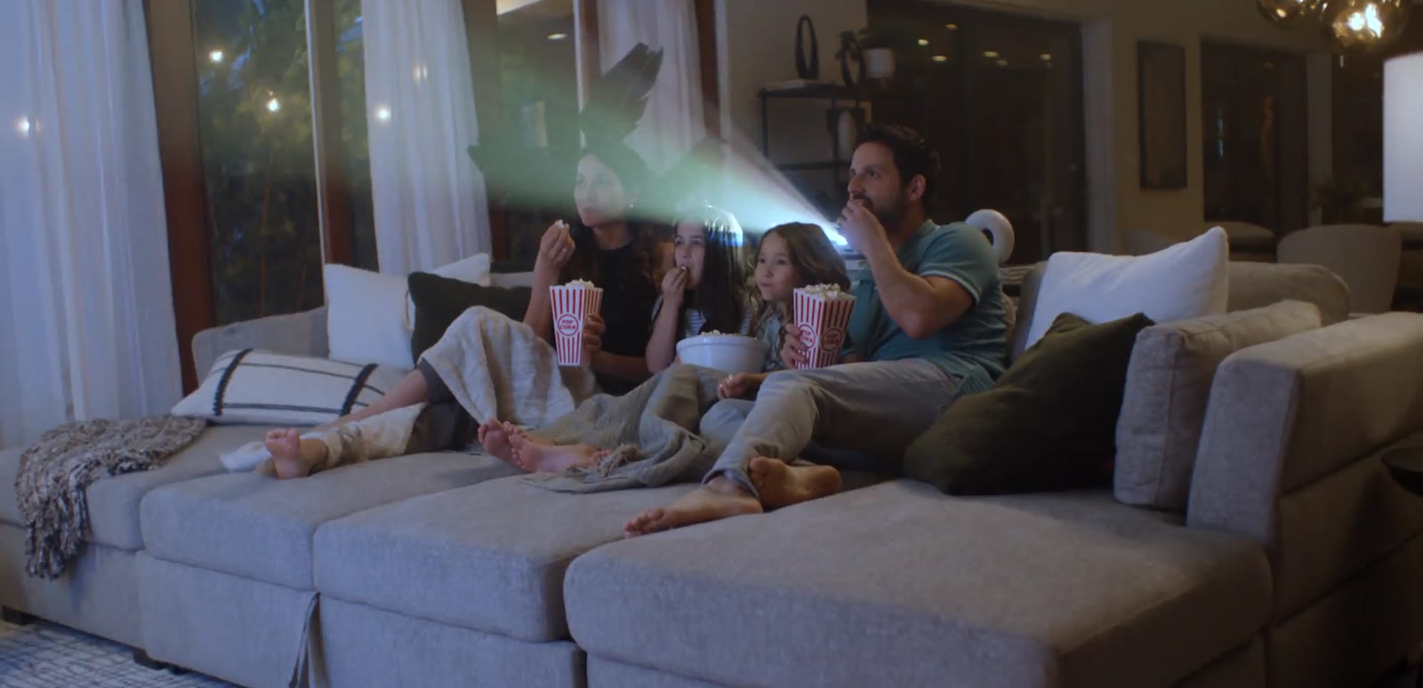 Family watching a movie on a sectional sofa