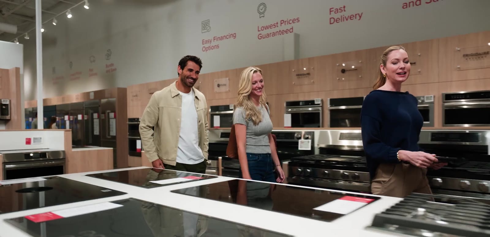 Associate guiding a couple through appliances